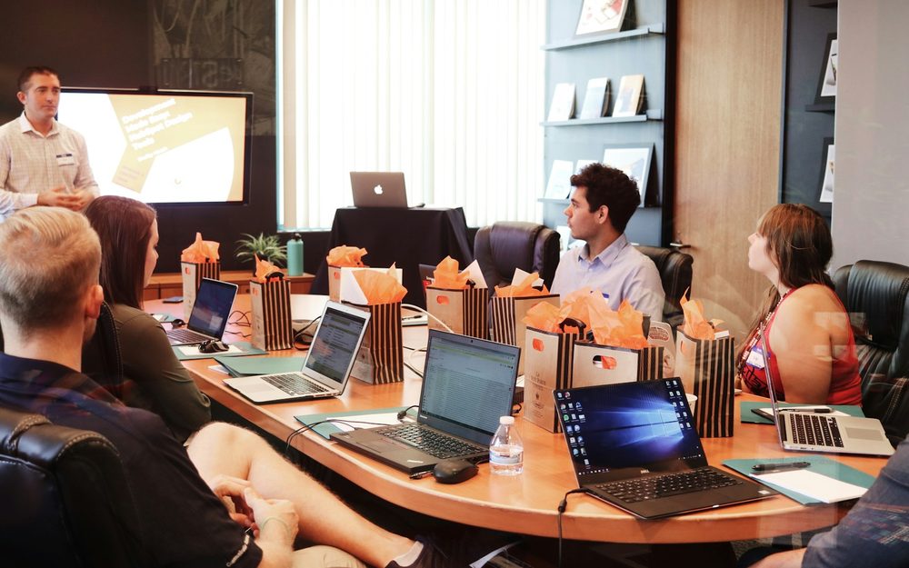 Colleagues collaborating over laptops in an open office