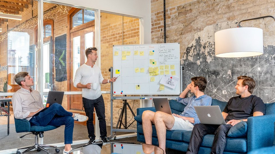 Team brainstorming at a whiteboard in a bright office